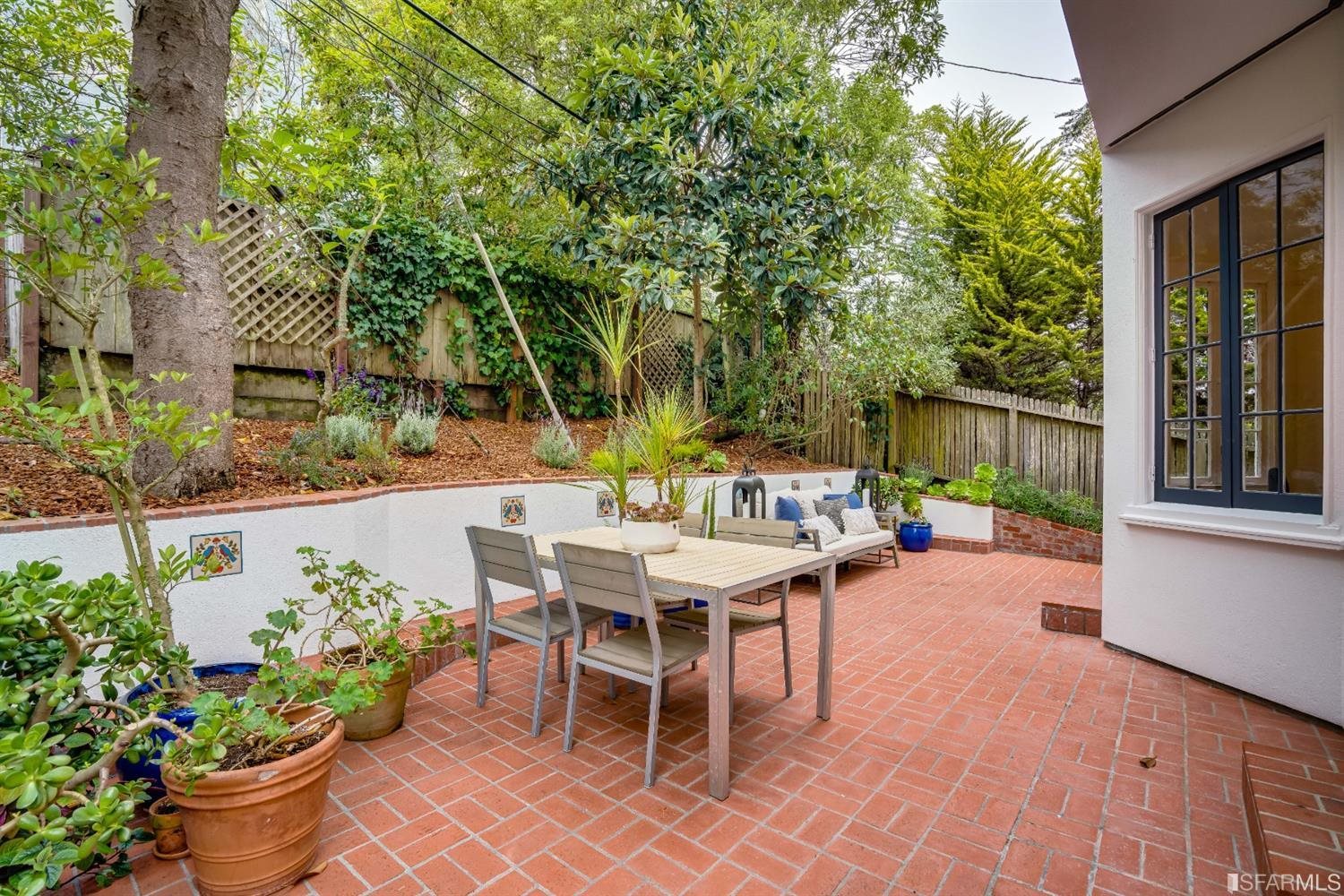 369 Pacheco Street San Francisco, CA 94116 - Photo 44 of 49 a view of a patio with table and chairs potted plants and large tree