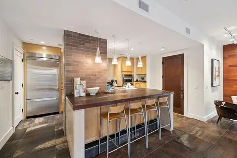 a kitchen with stainless steel appliances granite countertop a sink and a refrigerator
