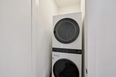 a front view of a building with a garden and trees