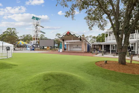an aerial view of ocean and residential houses with outdoor space and swimming pool