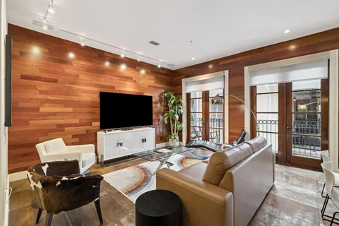 a living room with furniture wooden floor and a large window