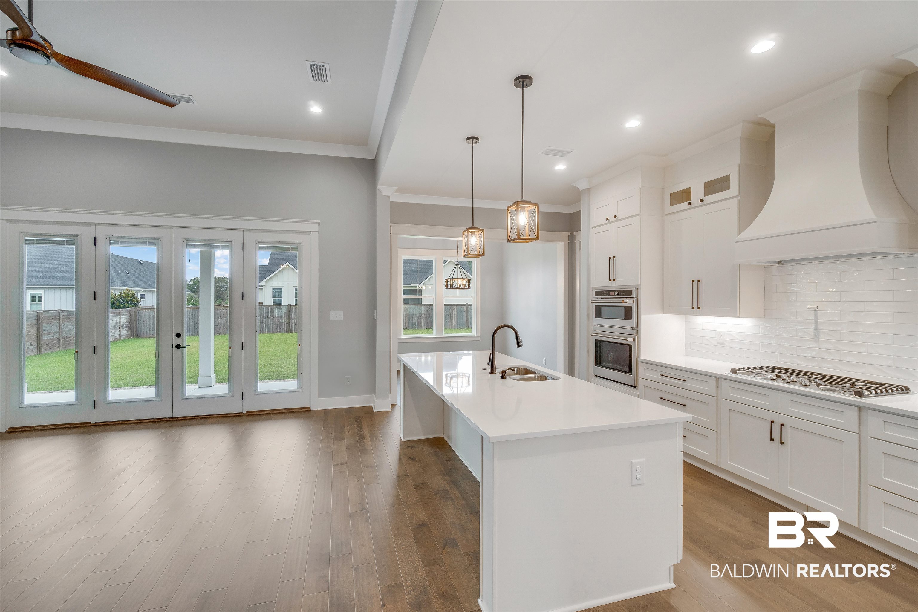 10985 Atrium Avenue Fairhope, AL 36532 - Photo 10 of 58 Kitchen with white cabinetry, tasteful backsplash, crown molding, decorative light fixtures, and glass insert cabinets