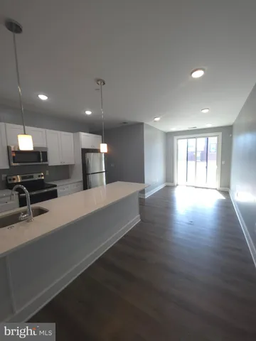 a large kitchen with stainless steel appliances a large counter top