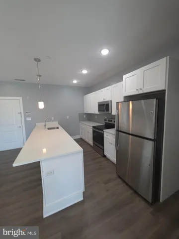 a kitchen with refrigerator cabinets and wooden floor