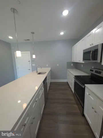 a large kitchen with stainless steel appliances a large counter top