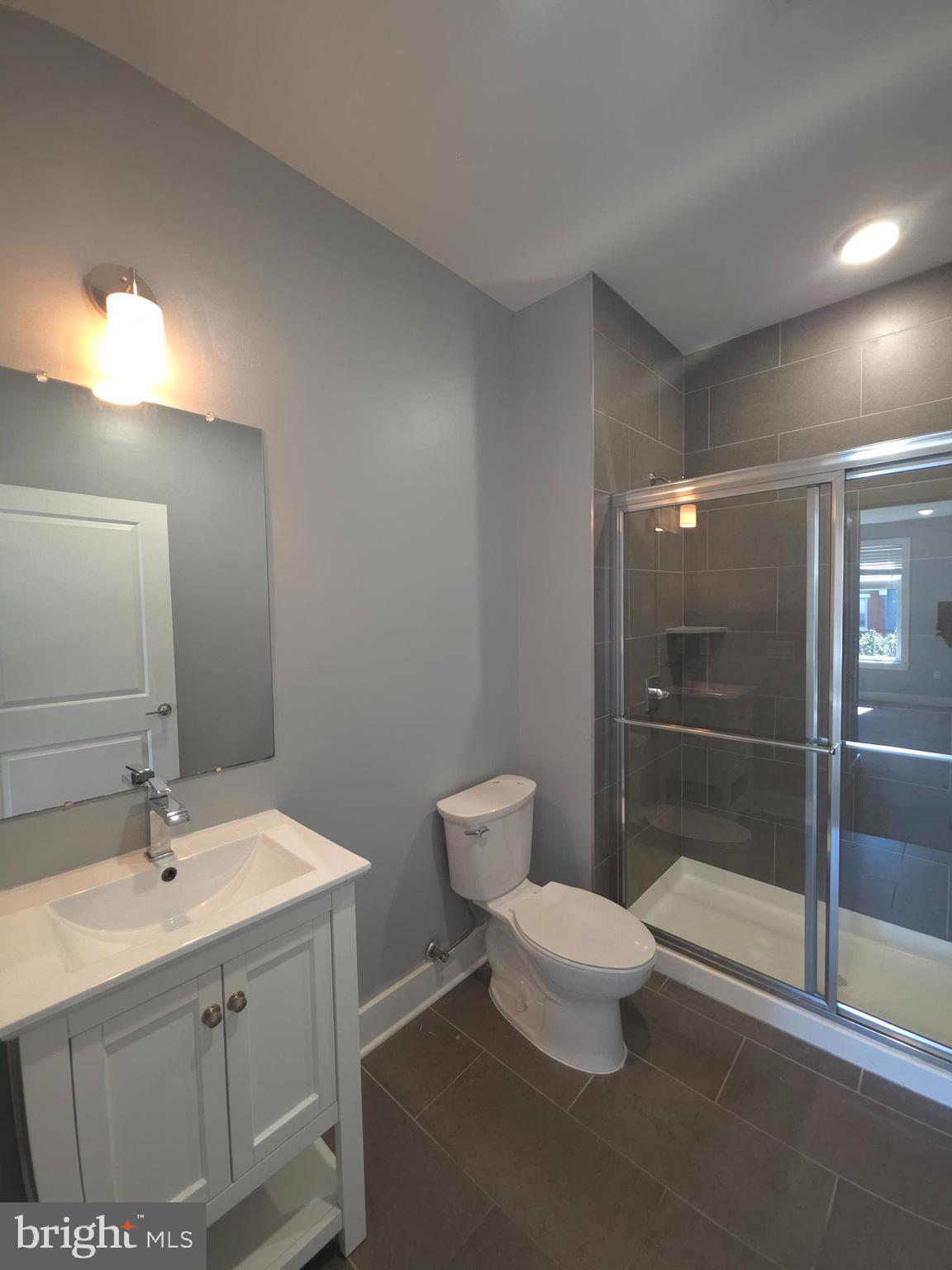 3925-29 Haverford Avenue, Unit 302 Philadelphia, PA 19104 - Photo 30 of 40 a bathroom with a toilet a sink and mirror