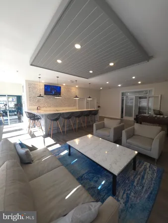 a living room with stainless steel appliances kitchen island granite countertop furniture and a large window