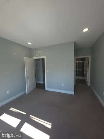 a kitchen with refrigerator and chairs