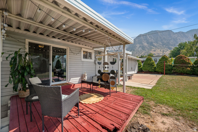 909 Rancho Boulevard Ogden, UT 84404 - Photo 25 of 27 Expansive outdoor living space featuring a composite deck with built-in seating areas, metal railings, and a covered patio with corrugated metal roofing