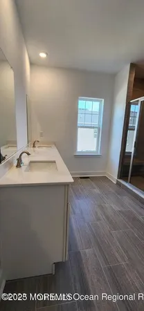 a bathroom with a sink a mirror and wooden floor