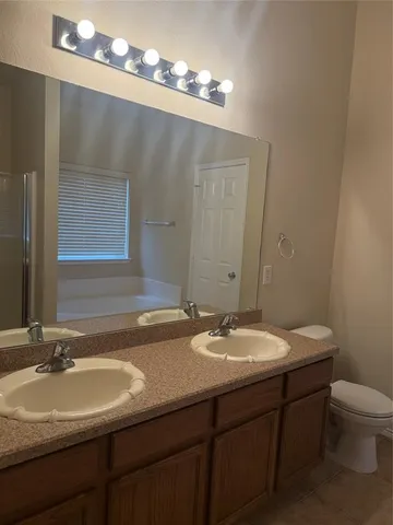 a bathroom with a sink a toilet and mirror