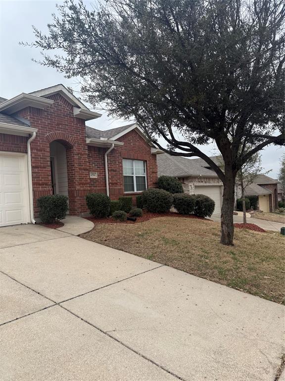 6506 Portside Ridge Lane Dallas, TX 75249 - Photo 2 of 23 a front view of a house with a yard and garage