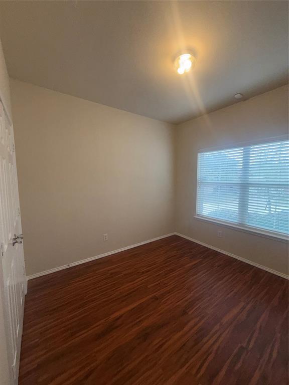 6506 Portside Ridge Lane Dallas, TX 75249 - Photo 8 of 23 a view of an empty room with wooden floor and a window