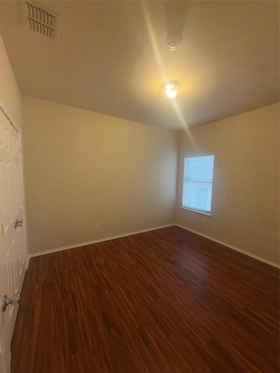 6506 Portside Ridge Lane Dallas, TX 75249 - Photo 9 of 23 an empty room with wooden floor and windows