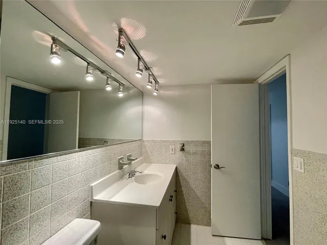 a bathroom with a sink a toilet and a mirror