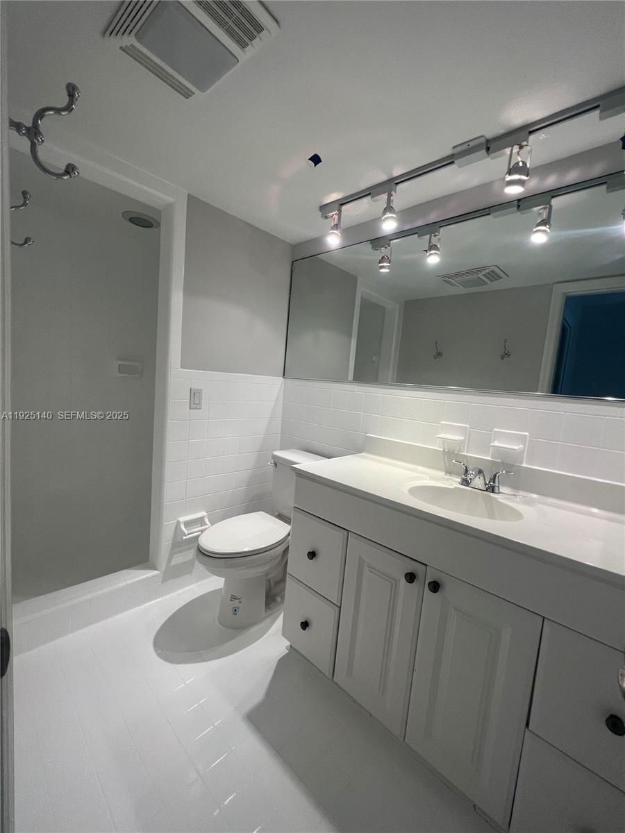 2230 Spanish Trail, Unit A Delray Beach, FL 33483 - Photo 16 of 23 a bathroom with a sink a toilet and a mirror