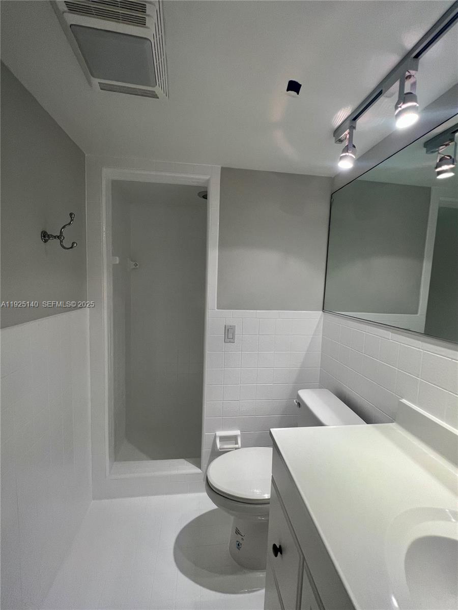 2230 Spanish Trail, Unit A Delray Beach, FL 33483 - Photo 17 of 23 a bathroom with a toilet a sink and shower