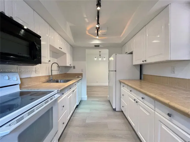 a large kitchen with stainless steel appliances granite countertop a sink and a stove
