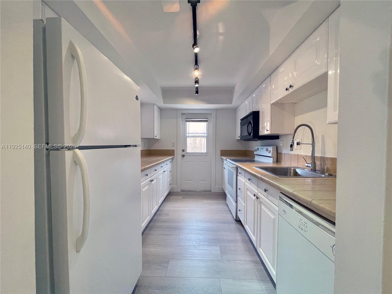 2230 Spanish Trail, Unit A Delray Beach, FL 33483 - Photo 5 of 23 a large kitchen with stainless steel appliances granite countertop a sink and a refrigerator