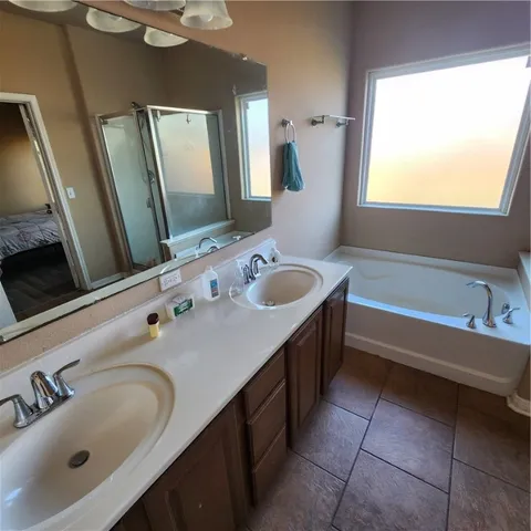 a bathroom with a tub sink and mirror
