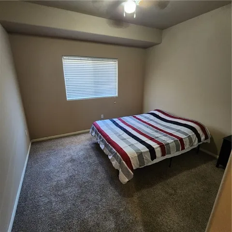 a bed sitting in a bedroom next to a window