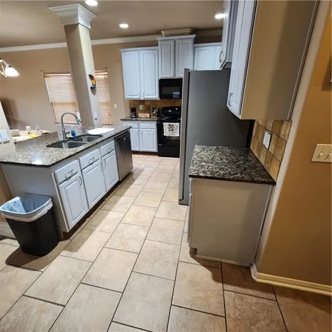 a kitchen with stainless steel appliances granite countertop a refrigerator and a stove