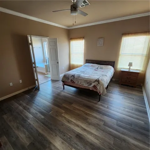 a spacious bedroom with a bed and a dresser next to a window