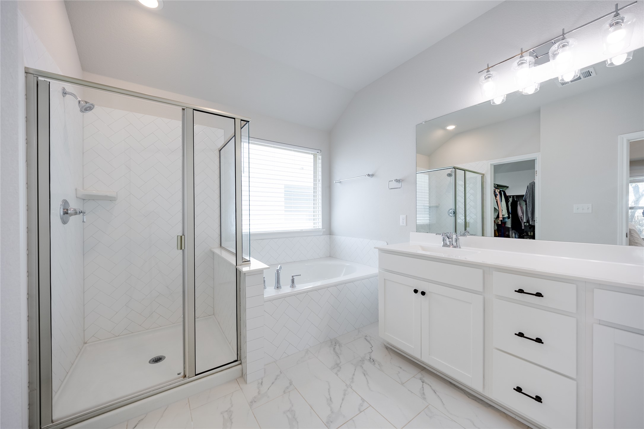 2021 Cartway Court Leander, TX 78641 - Photo 18 of 31 Bathroom with a garden tub, vanity, vaulted ceiling, marble finish floor, and a stall shower