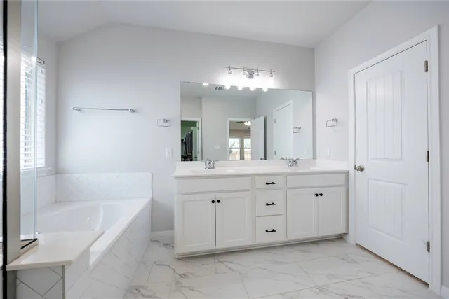 a spacious bathroom with a granite countertop sink mirror and a
