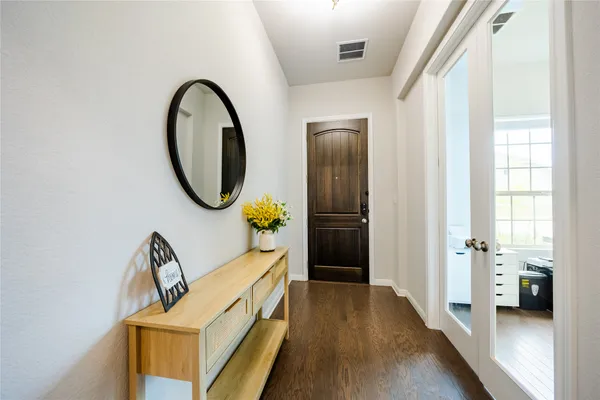 a view of a hallway with wooden floor and windows