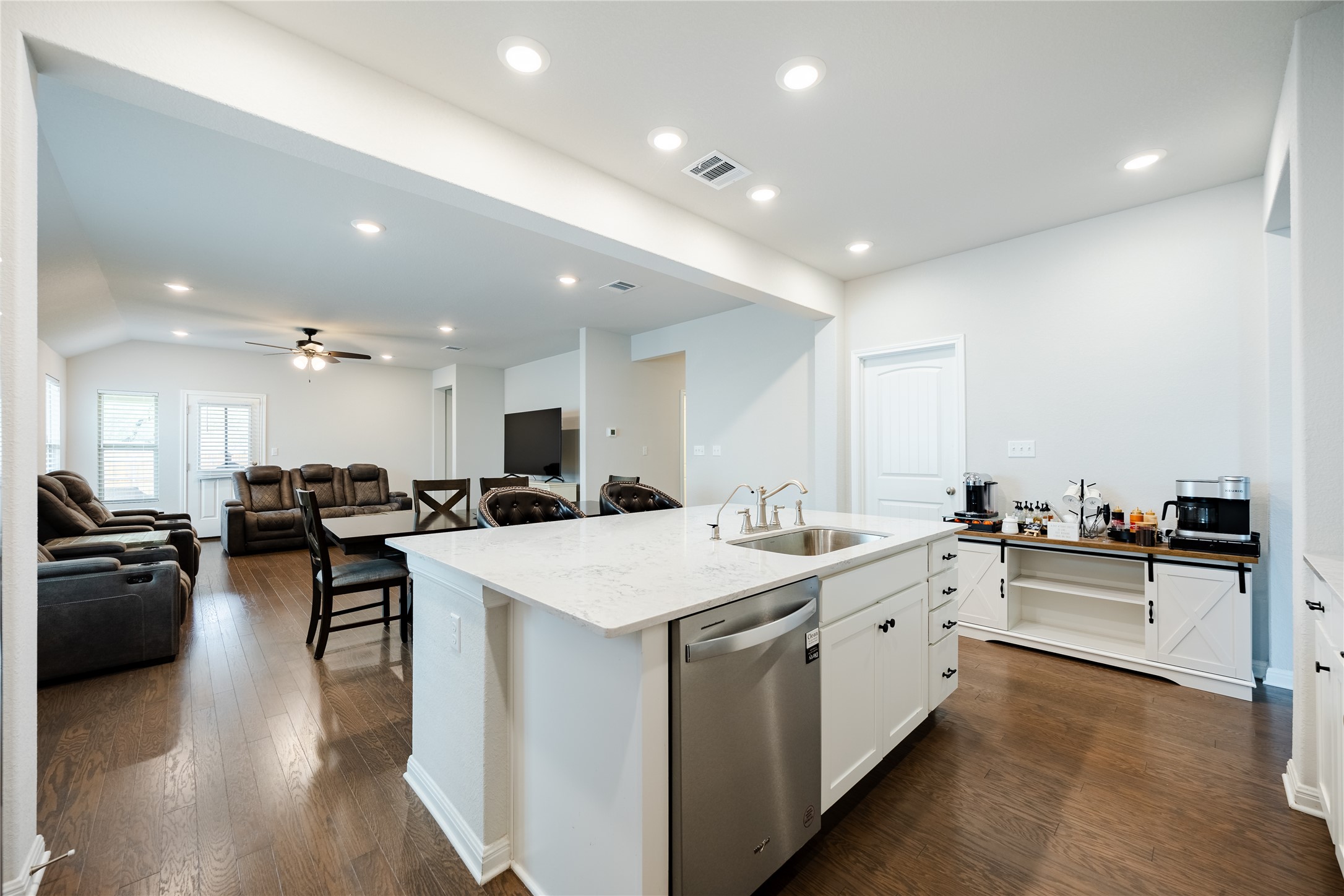 2021 Cartway Court Leander, TX 78641 - Photo 31 of 31 Kitchen featuring stainless steel dishwasher, white cabinets, visible vents, a sink, and open floor plan