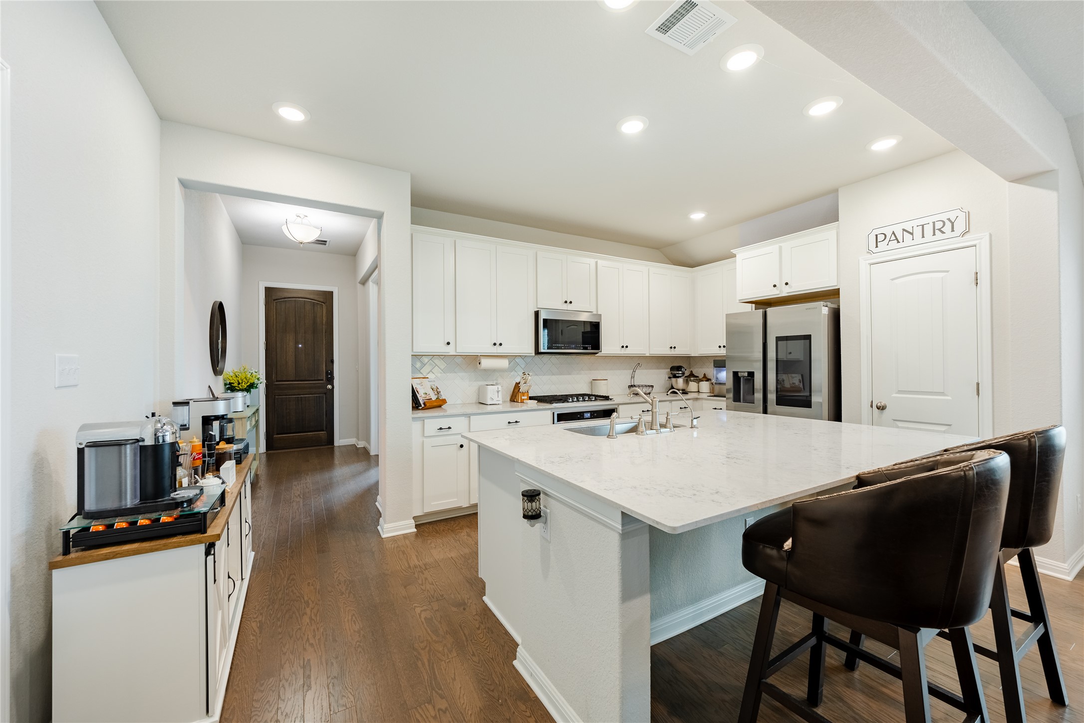2021 Cartway Court Leander, TX 78641 - Photo 6 of 31 Kitchen featuring visible vents, dark wood finished floors, white cabinetry, and stainless steel appliances