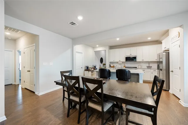 a kitchen with a sink a microwave a refrigerator and white cabinets