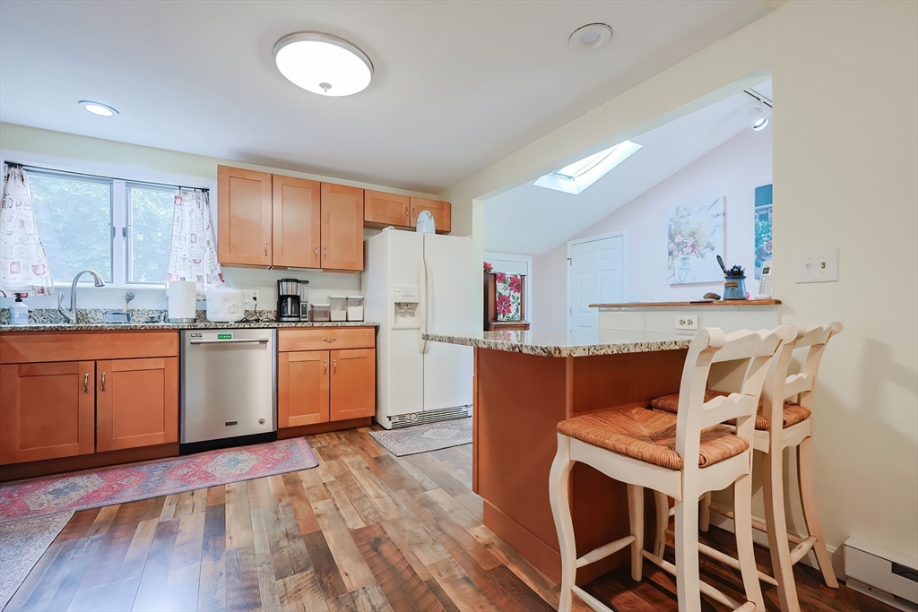 20 Ruth Drive Framingham, MA 01701 - Photo 13 of 42 a kitchen with wooden floors and white cabinets