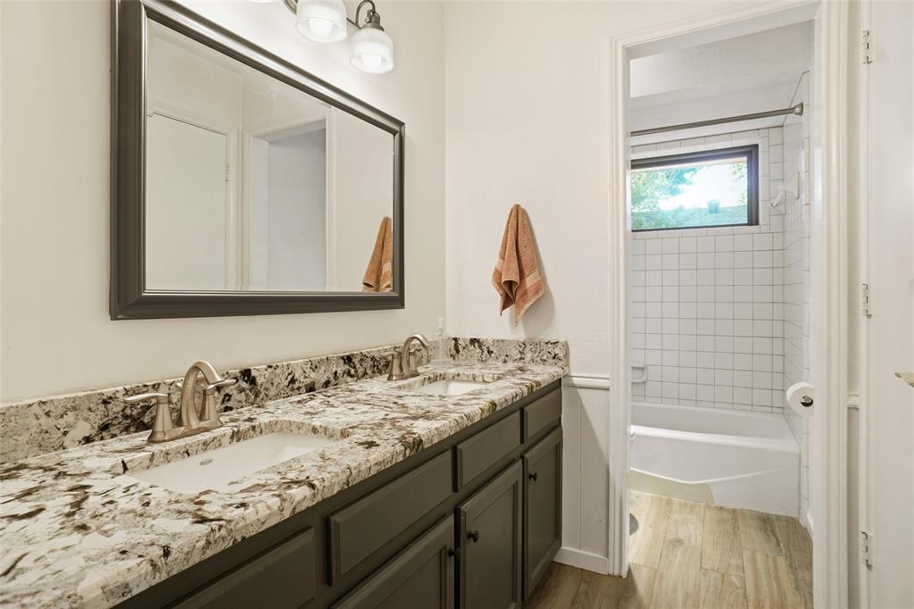 2109 Malone Street Denton, TX 76201 - Photo 21 of 36 a bathroom with a granite countertop sink a toilet and a mirror