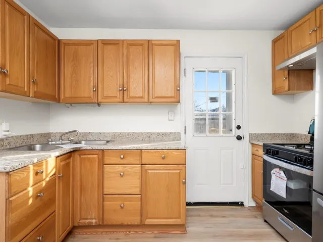 a kitchen with granite countertop cabinets stainless steel appliances and wooden floor