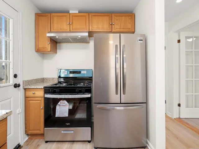 a kitchen with stainless steel appliances granite countertop a refrigerator and a stove