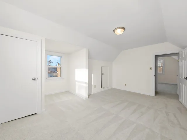 an empty room with windows and bathroom view