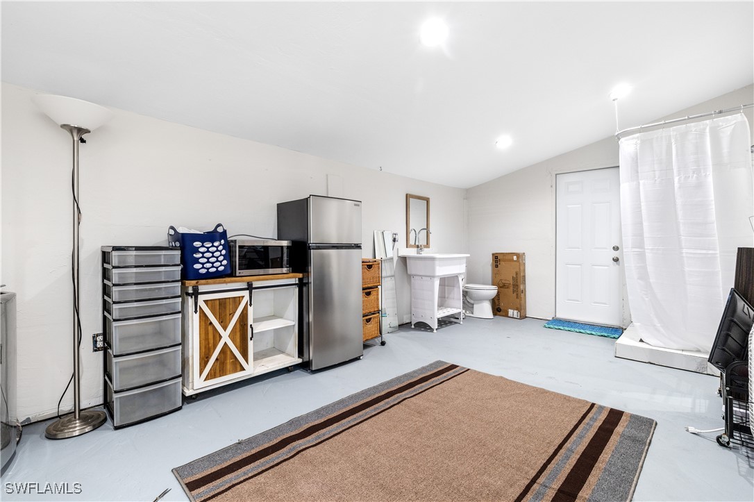 4673 Pine Island Road Matlacha, FL 33993 - Photo 17 of 29 a living room with furniture a flat screen tv and refrigerator
