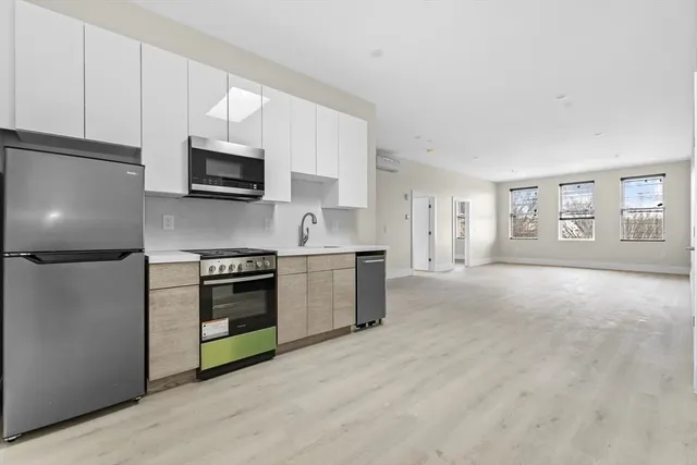 a kitchen with stainless steel appliances a stove a microwave and white cabinets