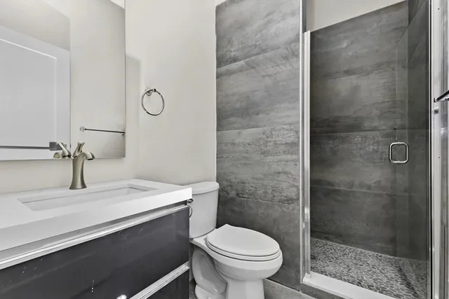 a bathroom with a sink a toilet and shower