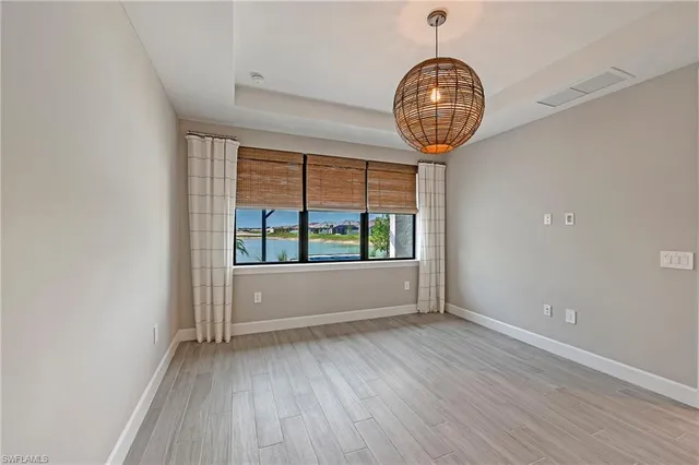 a view of a hallway with wooden floor and a window