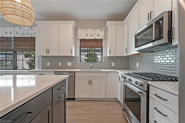 a kitchen with stainless steel appliances granite countertop a stove sink and cabinets