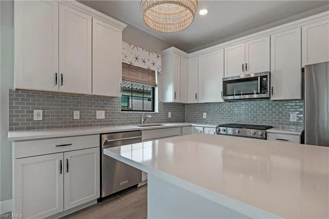 a kitchen with stainless steel appliances granite countertop a sink a stove and a microwave