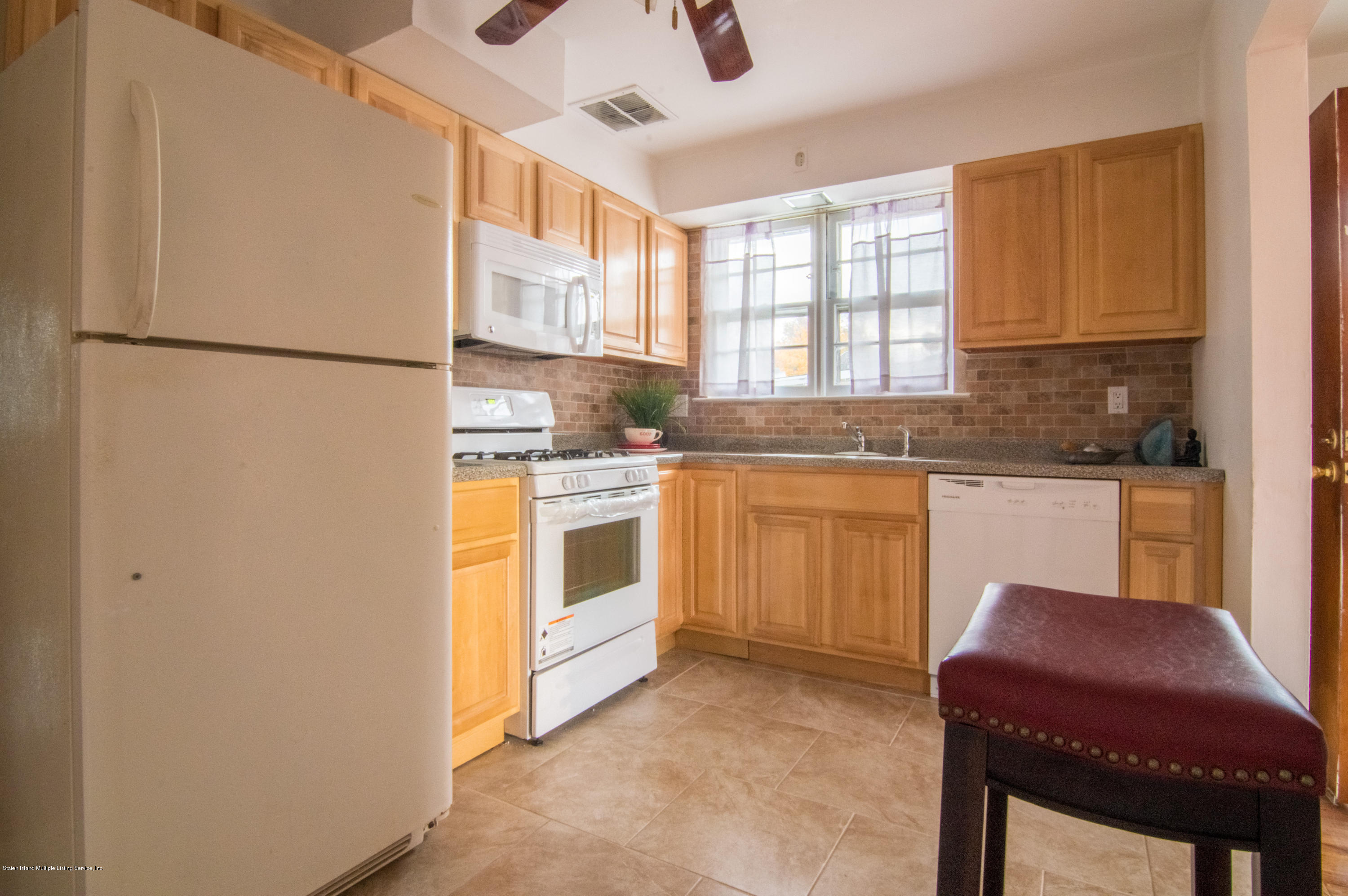 3298 Amboy Road Staten Island, NY 10306 - Photo 7 of 16 a kitchen with stainless steel appliances granite countertop a stove a sink dishwasher and a refrigerator