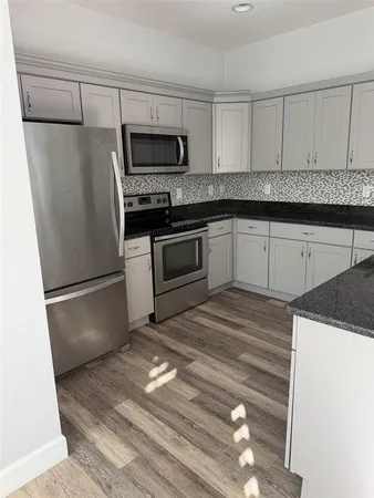 a kitchen with a refrigerator sink and cabinets