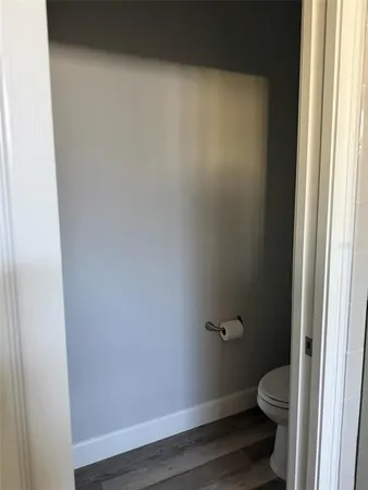 a bathroom with a granite countertop toilet and a window