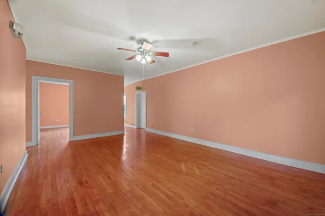 a view of empty room with wooden floor