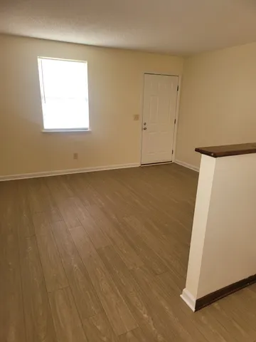 an empty room with a wooden floor and a window