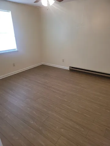 a view of a room with wooden floor and fan